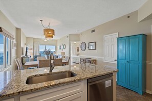 A modern kitchen with granite countertops, a stainless steel sink, and a dishwasher. - Tidewater 801 | Pools, Gym, Hot Tub, Wifi | Private Balcony | Ocean Front Views (Orange Beach)