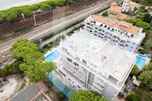 A multi-story hotel with a rooftop pool and a view of the surrounding area. - Prestige - Riva - Ground floor apartment with patio (Pineto)