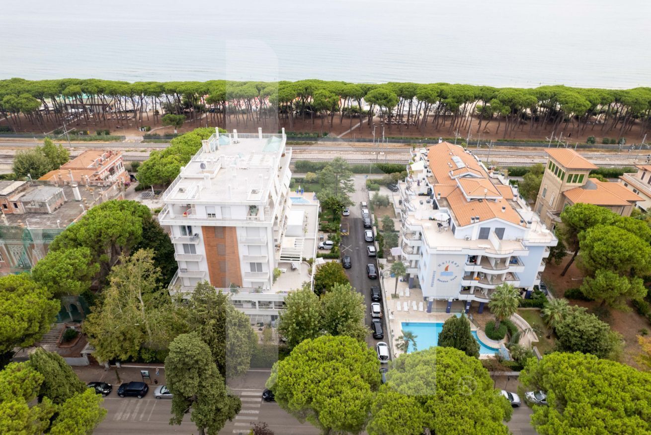 Un immeuble de grande hauteur doté de nombreux balcons et d’une piscine.