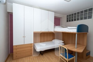 A room with a bunk bed, a desk with a chair, and a wardrobe. - Prestige - Riva - Ground floor apartment with patio (Pineto)