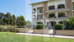 Un immeuble résidentiel à plusieurs étages, doté de balcons, d’une façade en briques et d’une entrée sécurisée par un portail.