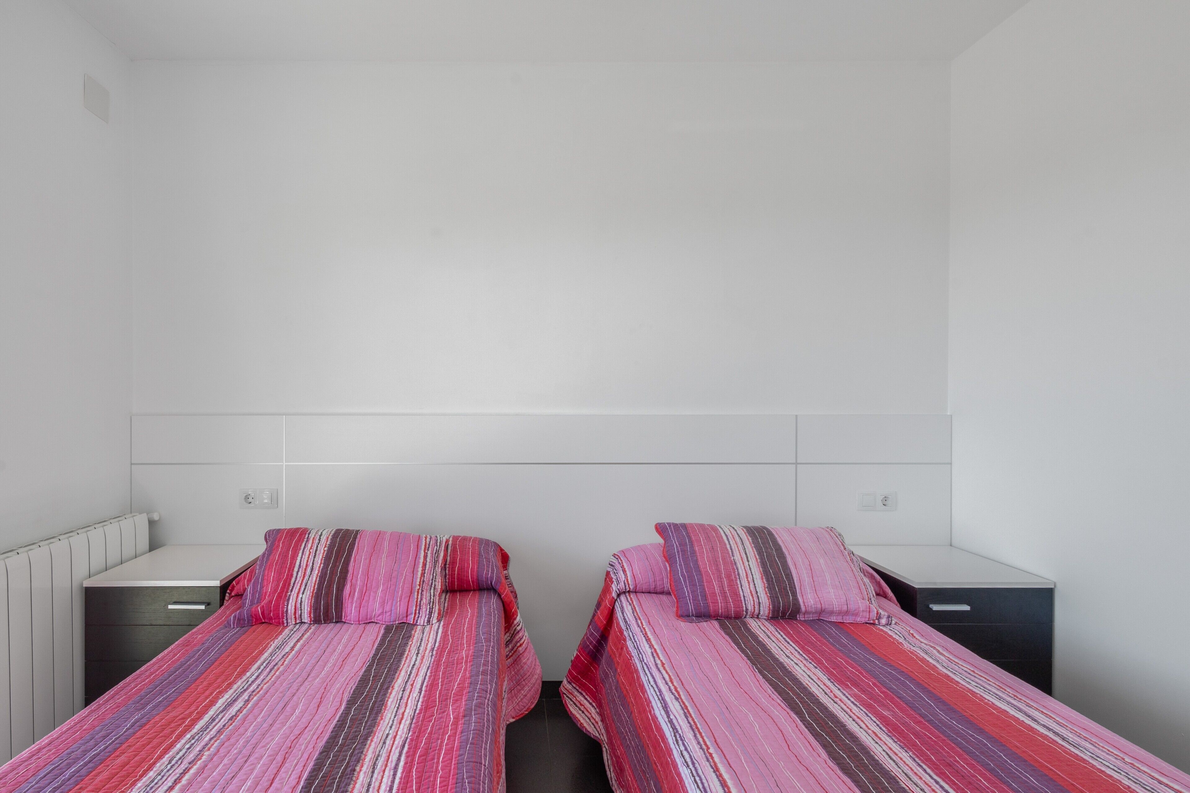A twin room with two beds, white walls, and a simple layout.