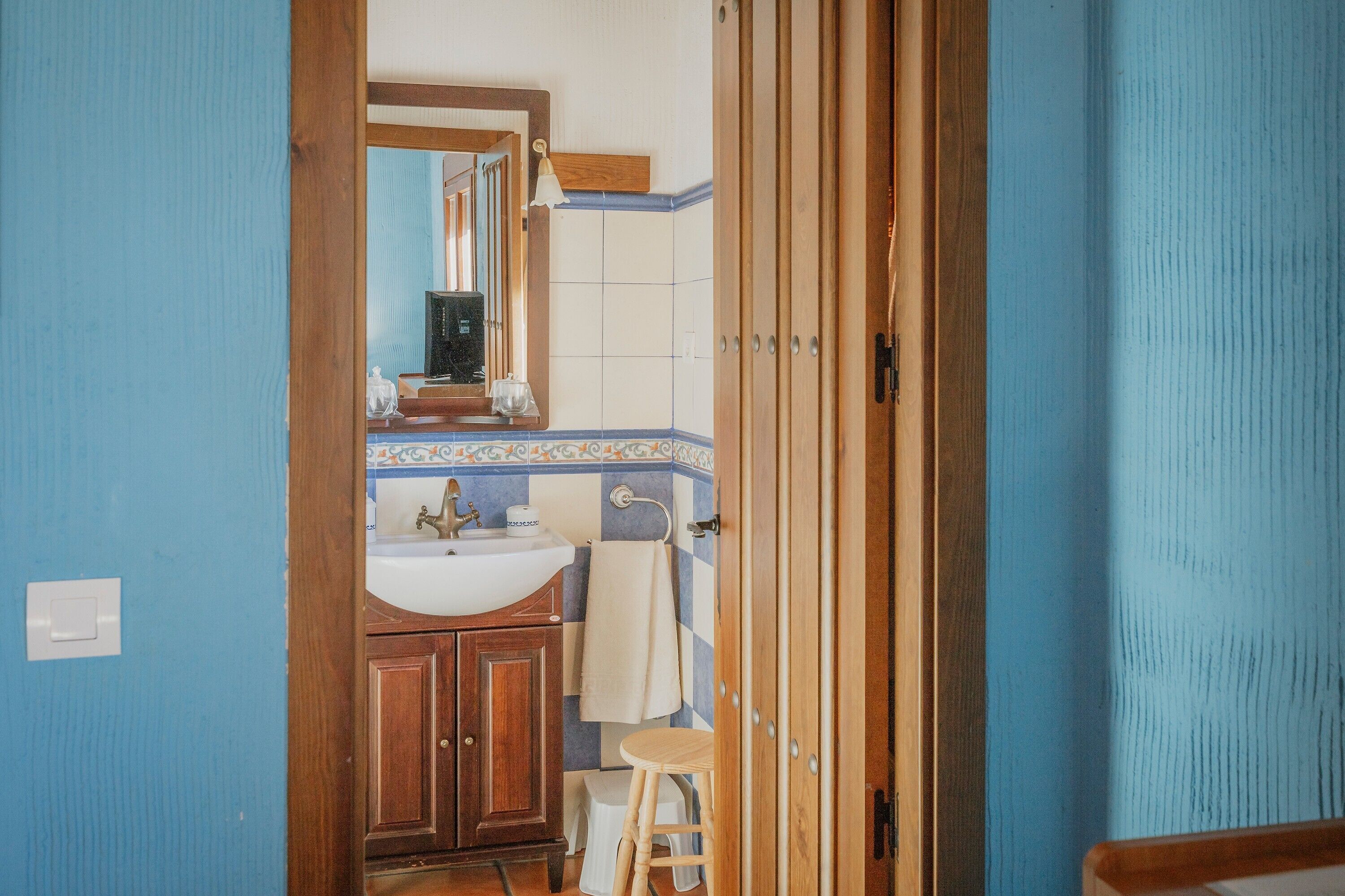 Ein Badezimmer mit Holzschrank, Waschbecken und Spiegel.