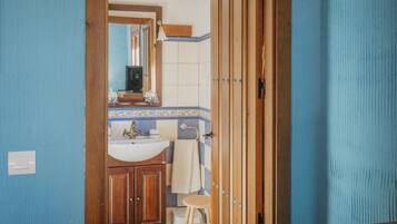 Ein Badezimmer mit Holzschrank, Waschbecken und Spiegel.