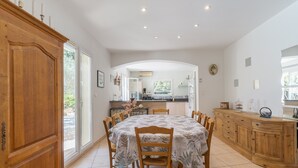 A dining area with a round table, chairs, and a wooden cabinet. - Holiday Home 'Calme Et Sans Vis À Vis' with Private Pool, Private Terrace and Wi-Fi (Salon-de-Provence)