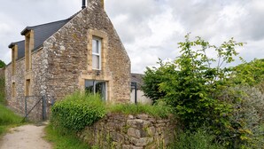 A stone house with a sloped roof, a visible chimney, and a gated entrance. - Holiday Home 'La Longère Du Cosquer' with Private Terrace, Garden & Wi-Fi (Baden)