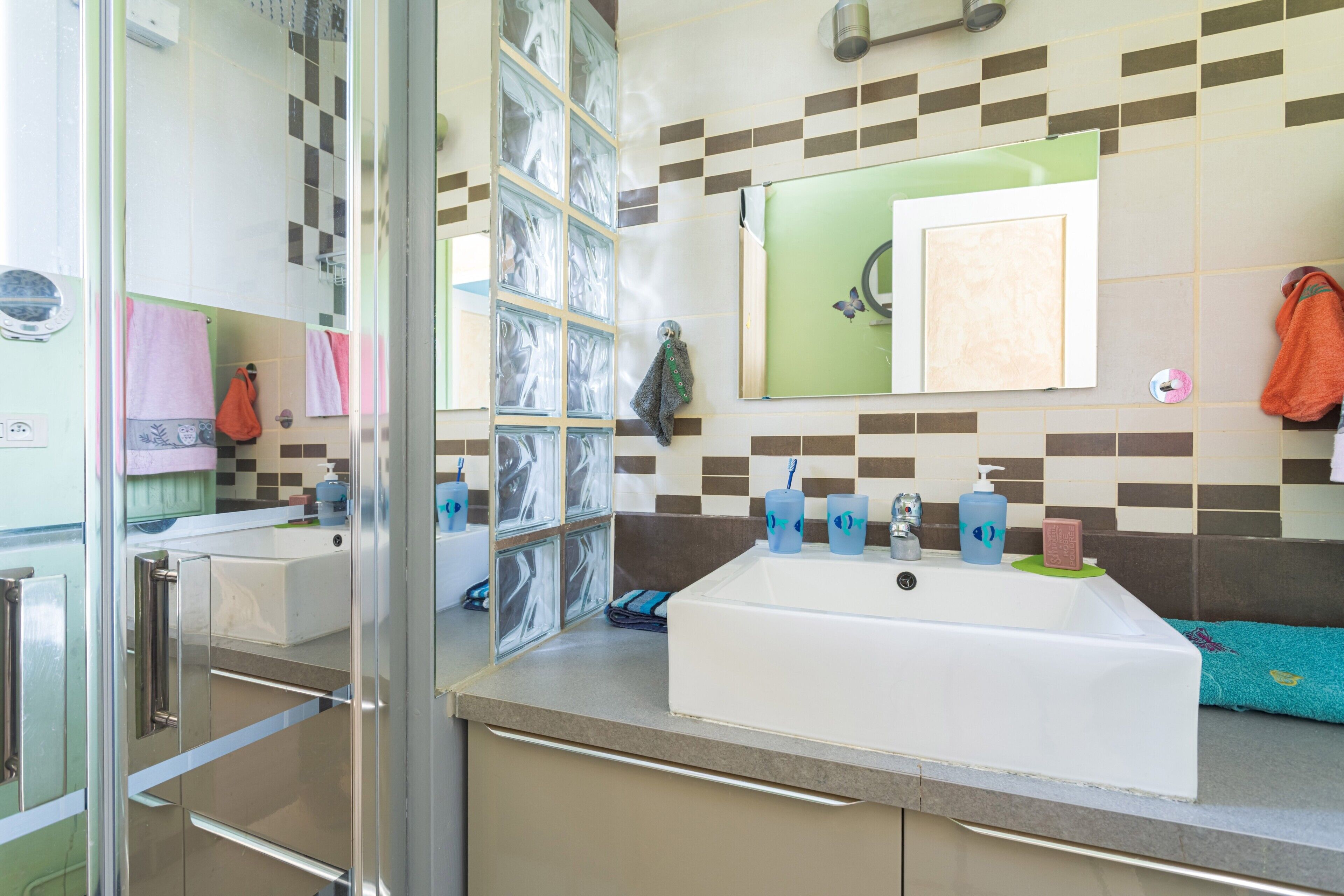 A bathroom with two sinks, a mirror, and a tiled backsplash.