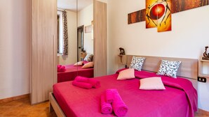 Una habitación de hotel con cama, espejo, cuadro y armario de madera.