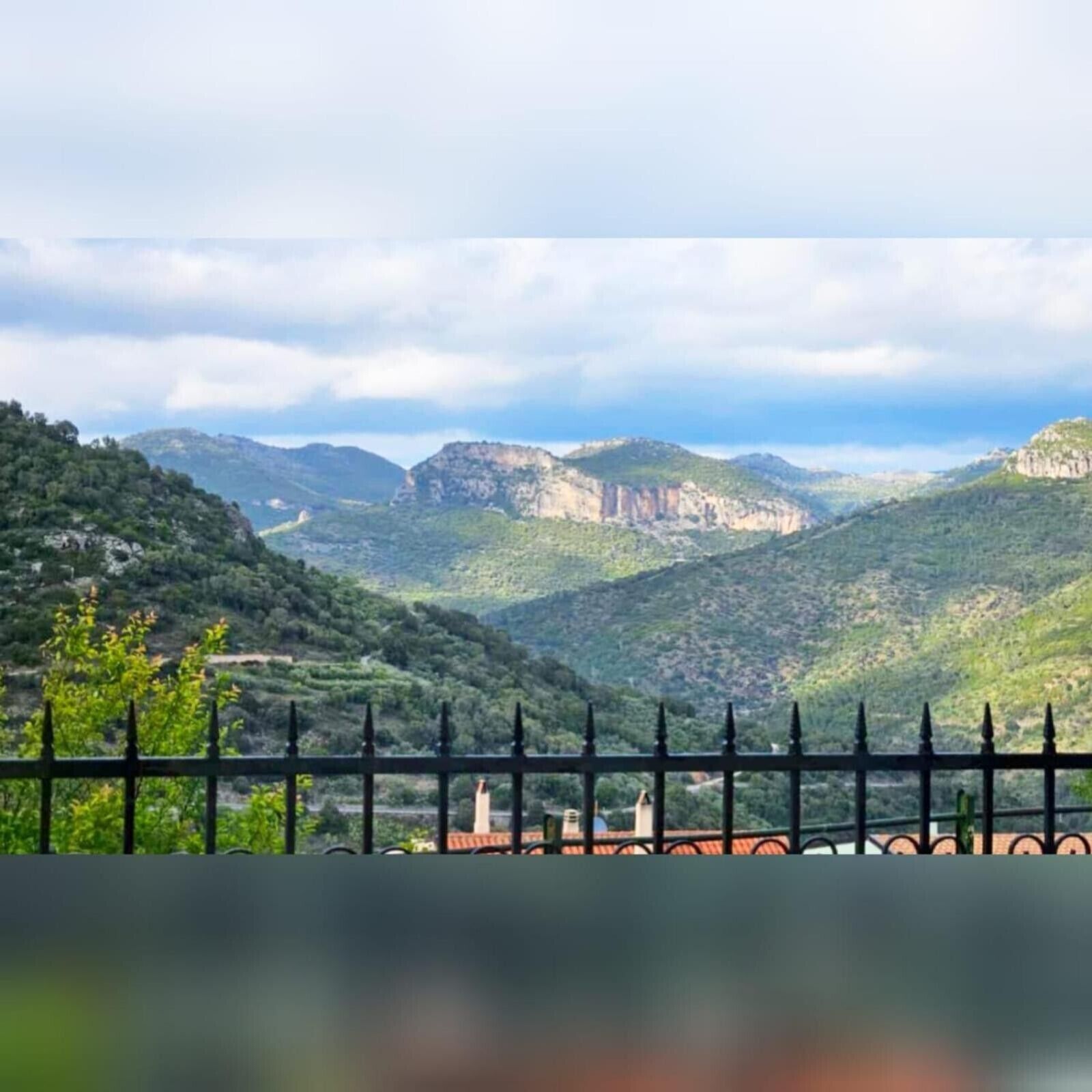 Paesaggio montuoso con vista su una valle e colline lontane.