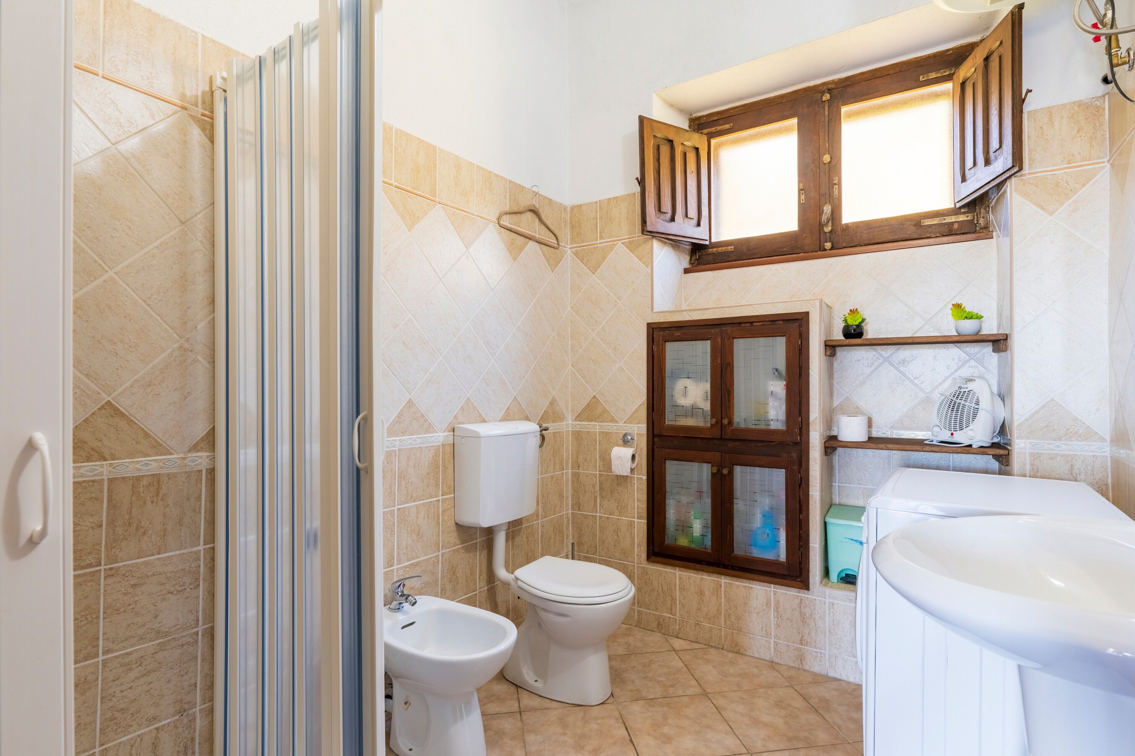 Un bagno con doccia, WC, bidet e lavandino.