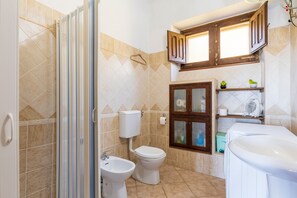 Ein Badezimmer mit Dusche, Toilette, Bidet und Waschbecken.