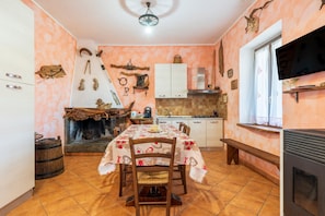 Una cocina con una mesa de comedor, sillas, chimenea y televisor.