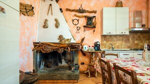 Una cocina rústica con chimenea de piedra, utensilios de madera y una estación para café.
