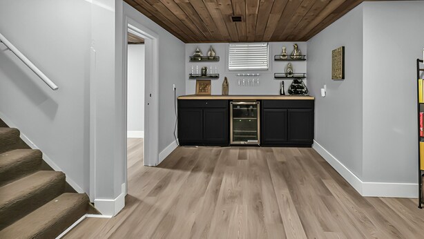 A modern kitchen with wooden ceiling beams, a built-in oven, and a countertop with various kitchen items. - Stay in a charming 2-bedroom house in Omaha with WiFi, AC, and a peaceful vibe. (Omaha)