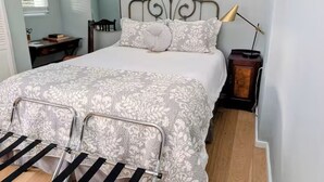 A bedroom with a bed, a desk, a chair, a lamp, and a window. - European Style b&b in Topanga (Topanga)