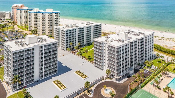 A high-rise hotel with multiple floors, a central courtyard, and a beach view.