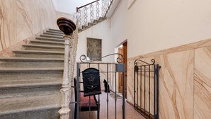 A marble staircase with a metal gate and a wooden door at the top. - Apartment 'La Casa Vintage' with Private Garden, Wi-Fi and Air Conditioning (Firenze)