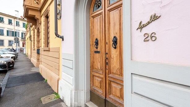 A street view with a building featuring a double wooden door with a nameplate reading 'Guella 26'. - Apartment 'La Casa Vintage' with Private Garden, Wi-Fi and Air Conditioning (Firenze)