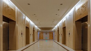 A long, narrow hallway with elevators on both sides, leading to a door at the end.