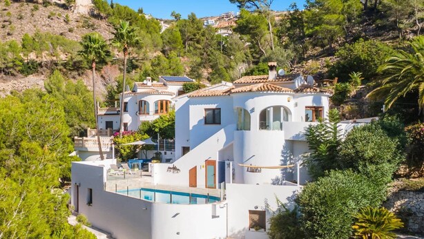 A white villa with a pool, surrounded by lush greenery and hills. - Villa Kmar by Villa Plus (El Poble Nou de Benitatxell)