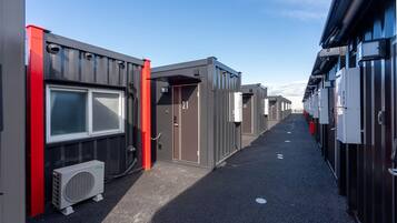 A row of compact, modern buildings with numbered doors, likely indicating individual units or rooms.