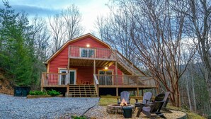 A two-story log cabin with a balcony, a fire pit, and outdoor seating. - Hot Tub Soaks Under the Stars, Firepit S'mores & Secluded Mountain Vibes - A Country Retreat (Gatlinburg)