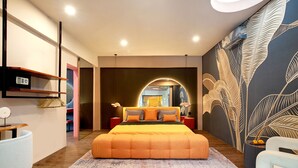 A modern bedroom with a large bed, a mirror, and a wall with a leaf pattern.