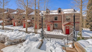 A row of townhouses with red doors and a snow-covered ground. - Rr59b3 (Breckenridge)