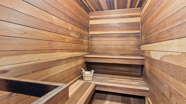 Un sauna avec des murs et des bancs en bois.
