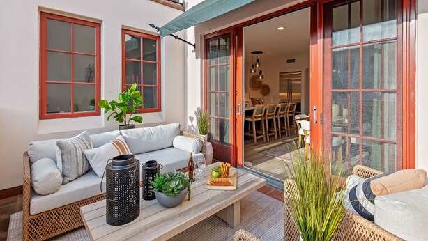 A cozy outdoor seating area with a sofa, table, and potted plants. - Luxe Two Story Condo in the Heart of Downtown SB! (Santa Barbara)