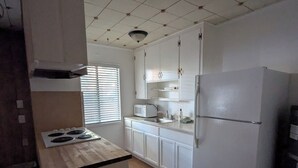 A kitchen with white cabinets, a stove, a refrigerator, and a microwave. - Heavenly Gates (South Lake Tahoe)