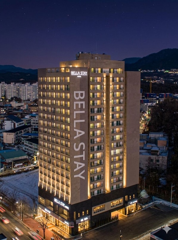 A multi-story hotel with a prominent 'Bella Stay' sign, featuring a modern architectural design with a flat roof and numerous windows. - Bella Stay Hotel (Chuncheon)
