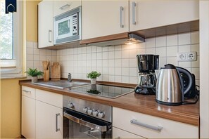 Eine Küche mit Mikrowelle, Kaffeemaschine, Wasserkocher und Backofen.