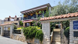 Un edificio di due piani con un balcone, pareti in pietra e un cartello che indica 'Apartment Free'.