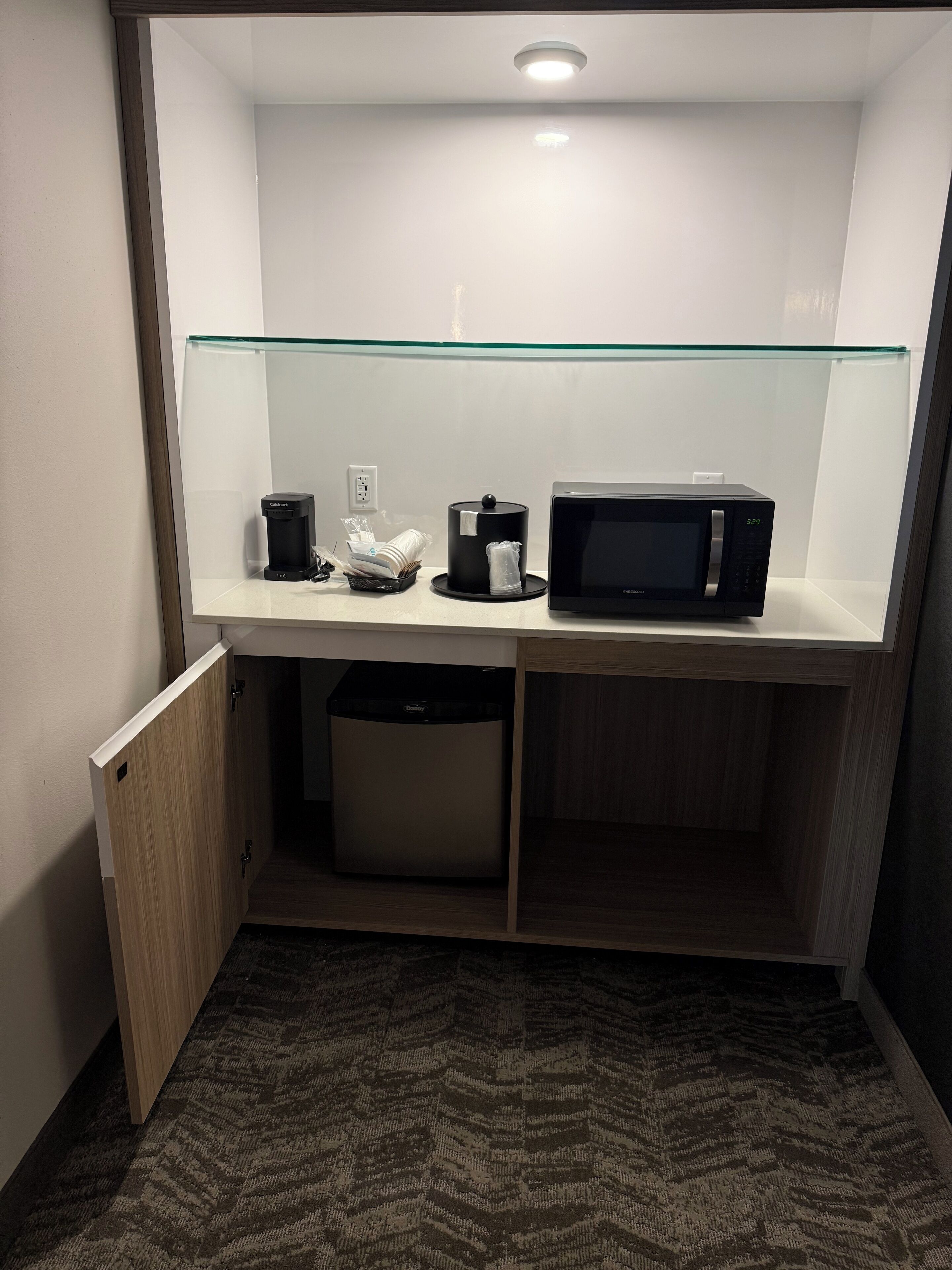 A compact kitchenette with a microwave, coffee maker, and a small refrigerator.