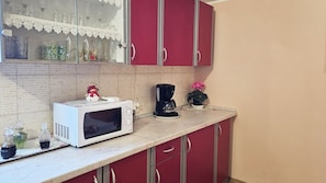 A kitchen with a microwave, coffee maker, and decorative items on the counter.