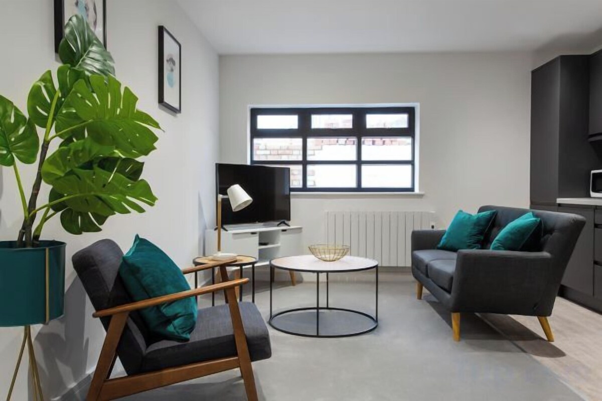 Un salon moderne avec un canapé, un fauteuil et une table basse.