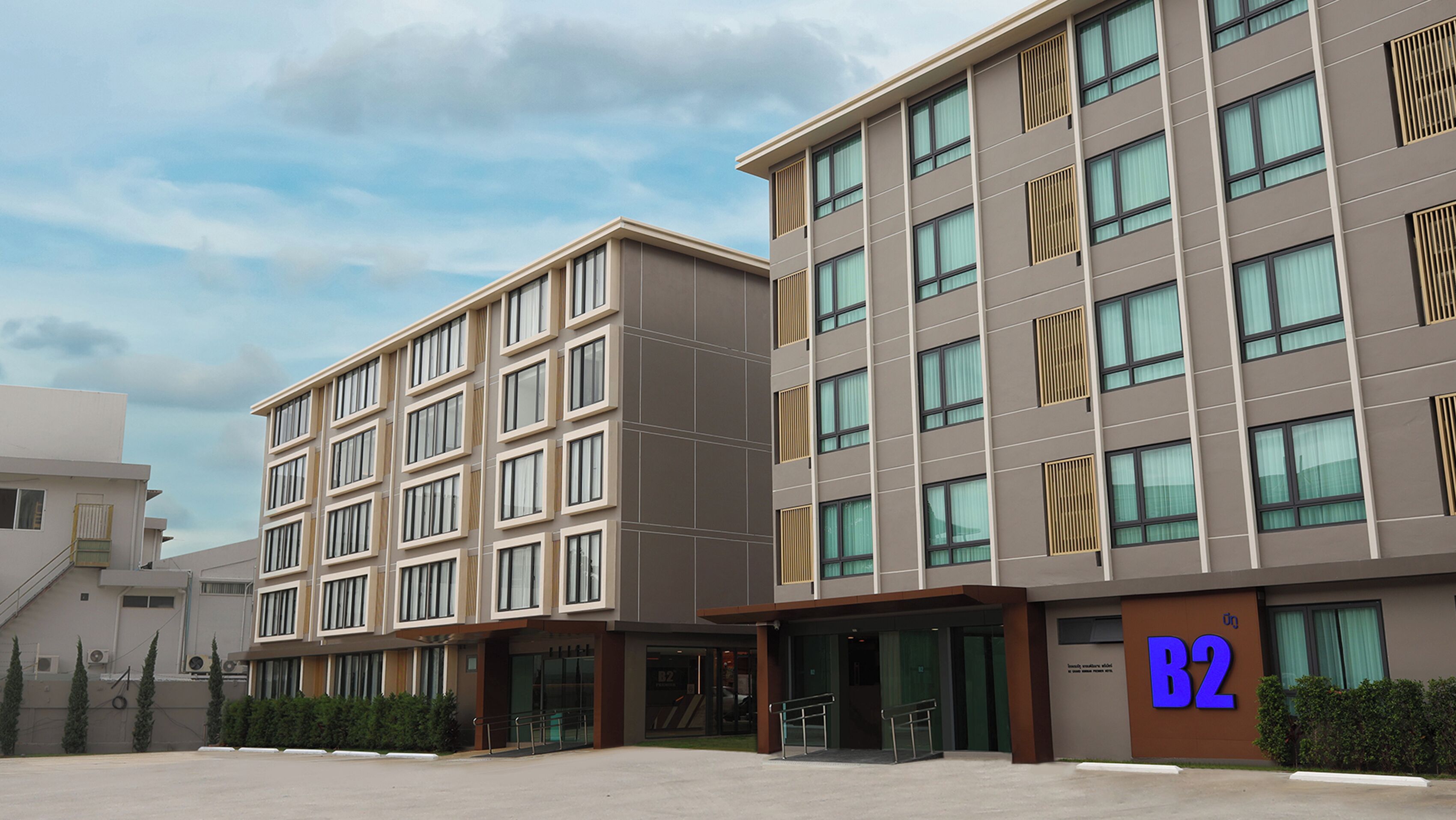 A modern building with multiple floors, large windows, and a sign indicating room number B2.