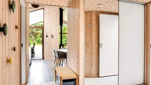 A wooden interior with a dining area, a bench, and a sliding door. - 5 Star Holiday Home in Vaeggerlose (Vaeggerlose)