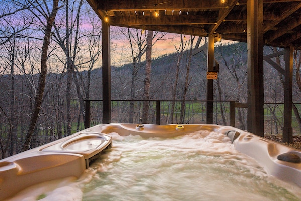 A hot tub with a view of a forested area.