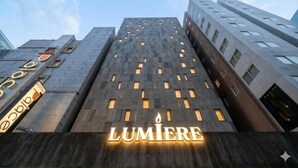 A tall building with the name 'LUMIERE' illuminated on the facade. - Yeoksam Lumiere (Seoul)