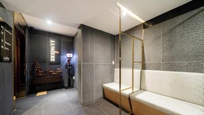 A modern lobby with a reception desk, a seating area, and a wall-mounted sign. - Yeoksam Lumiere (Seoul)