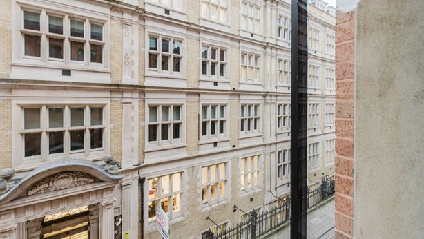 A multi-story building with a classical architectural style, featuring symmetrical windows and decorative moldings.