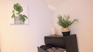 A room with a black cabinet, a white wall, and a framed plant artwork. - The Hampstead Hideaway (London)