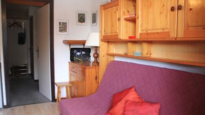 A room with a purple sofa, a wooden cabinet, and a small table with a lamp. - Veronica Vr79 Nature & Mountain 3 Pers (Chatel)