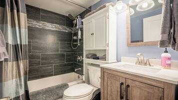 Een haardroger, handdoeken, zeep, toiletpapier