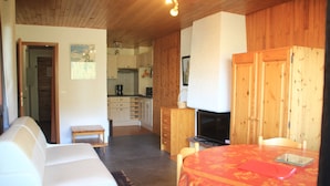 A cozy room with a sofa, a dining table with a red tablecloth, wooden cabinets, and a television. - Rhododendrons Rd501 Center & Telecabine 4 Pers (Chatel)