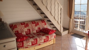 Ein gemütliches Zimmer mit einer Holzsofa, einer Treppe und einem Fenster mit Blick.
