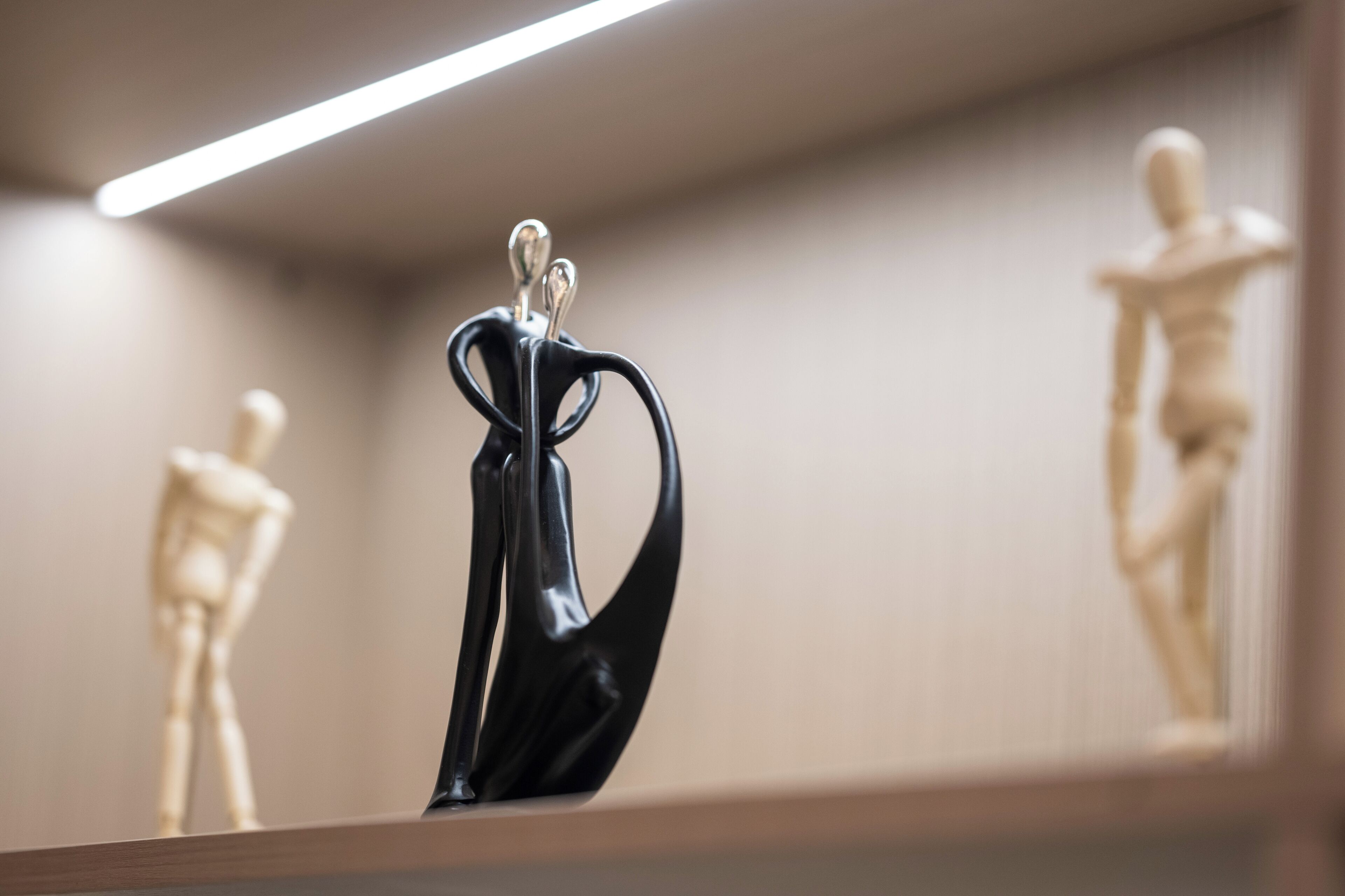 Une sculpture représentant une figure humaine dans une pose dynamique, placée sur une étagère.