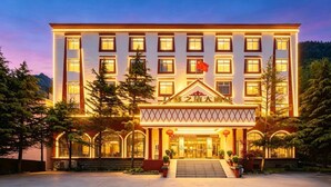 A multi-story hotel with a prominent entrance, large windows, and a flag.